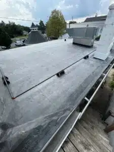 roof cement displacing standing water on a flat roof substrate